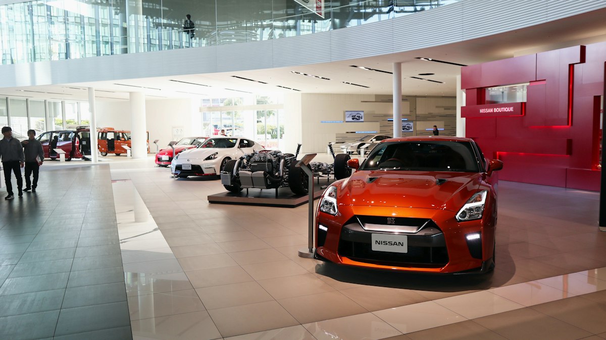 A car dealership showroom floor with several vehicles on display under bright lighting