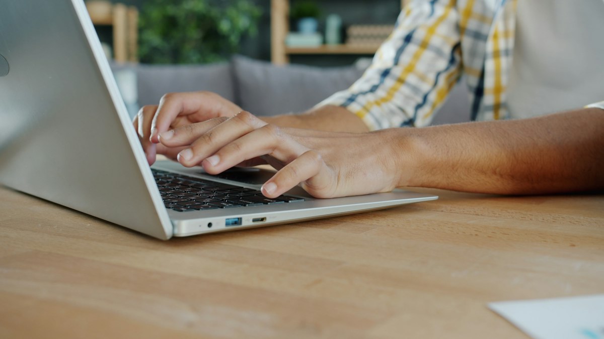A person typing a message into a website chat widget on a laptop