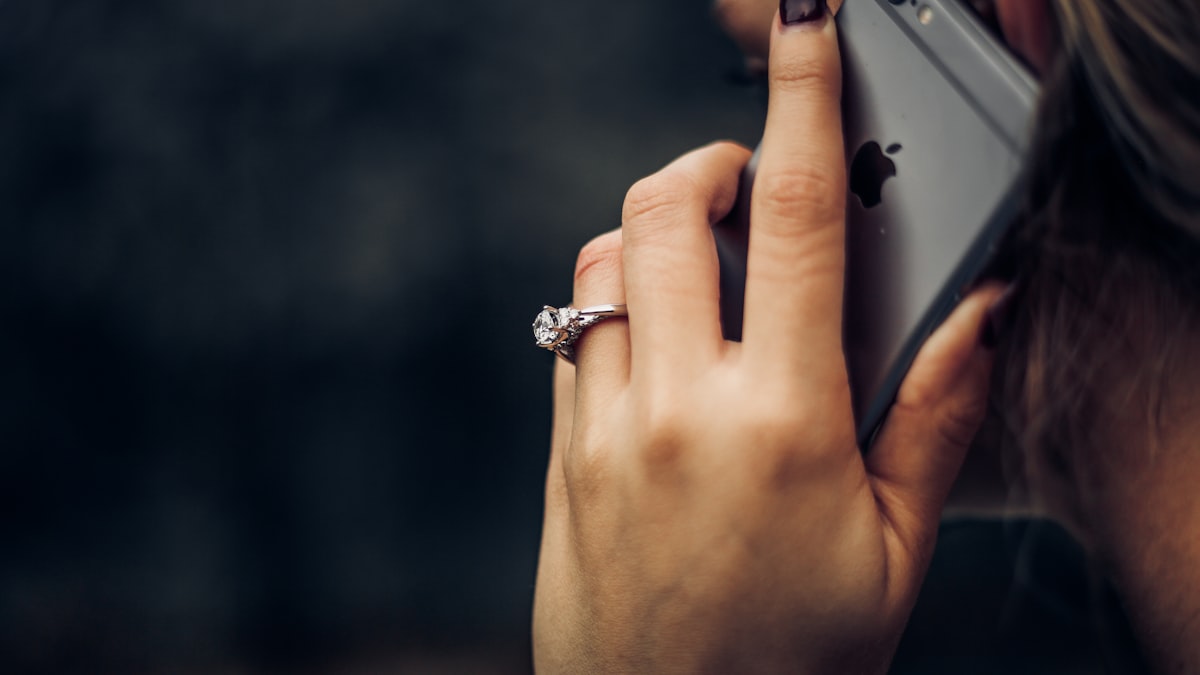A woman holding a phone to her ear during a call, the moment a caller either hears a natural reply or an awkward pause
